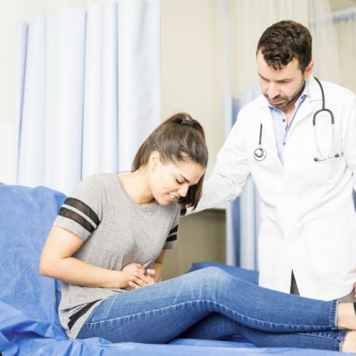 Especialista en gastroenterología atiende a mujer con dolor de colon